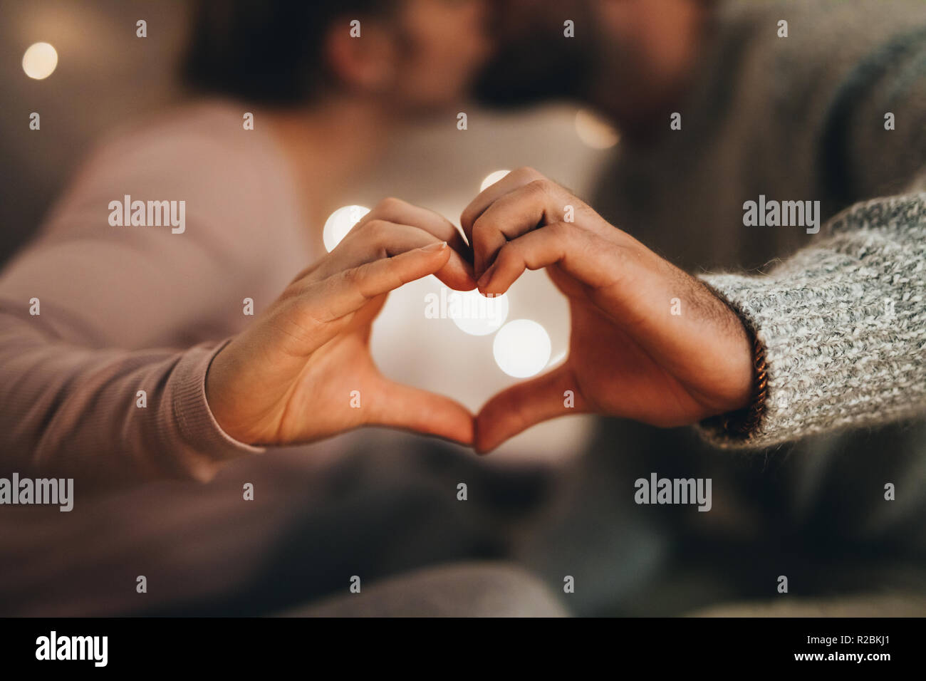 Romantisches Paar, das Symbol des Herzens mit ihren Händen. Mann und Frau küssen einander, während Sie die Liebe, die Zeichen mit der Hand. Stockfoto