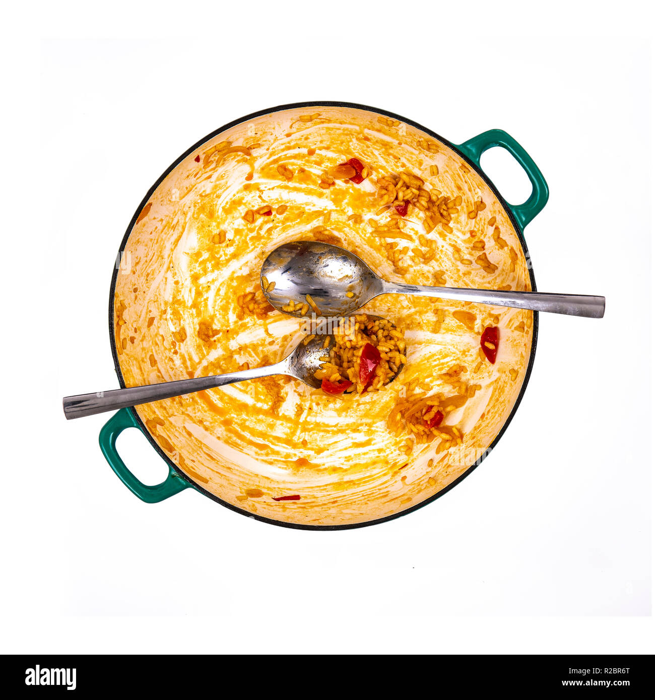 Pan der übrig gebliebene Paella mit Löffeln auf weißem Hintergrund Stockfoto