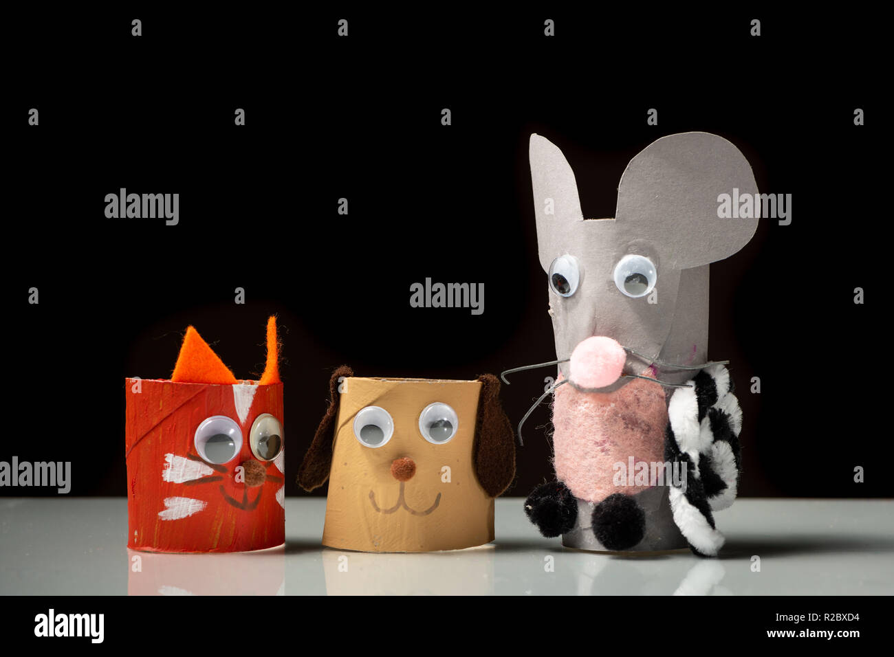 Nahaufnahme von Katze, Hund und Maus aus klopapierrolle durch ein Kind,  schwarzer Hintergrund Stockfotografie - Alamy