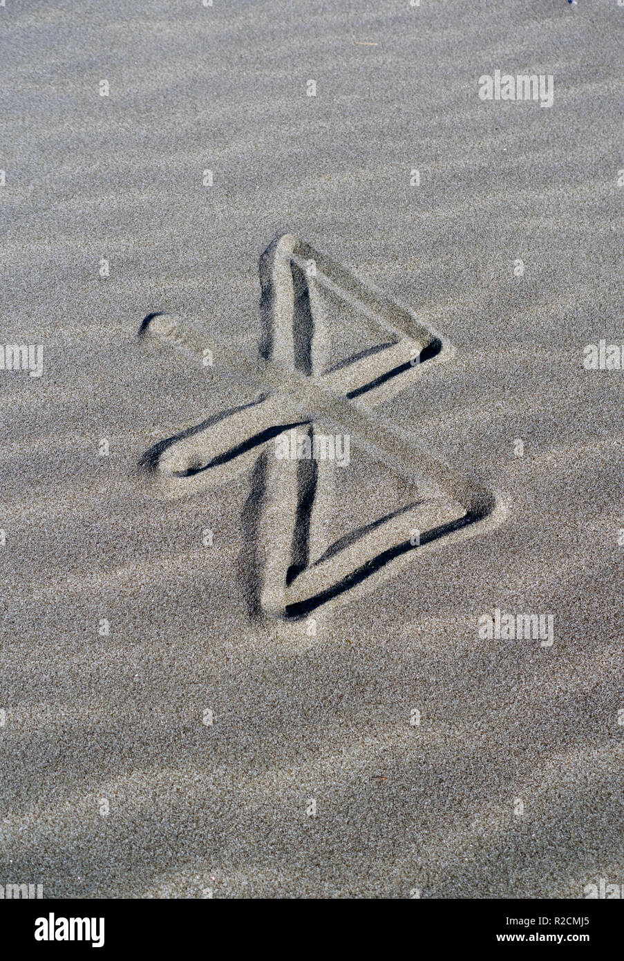 Bluetooth Logo skizziert auf dem Sand Stockfoto