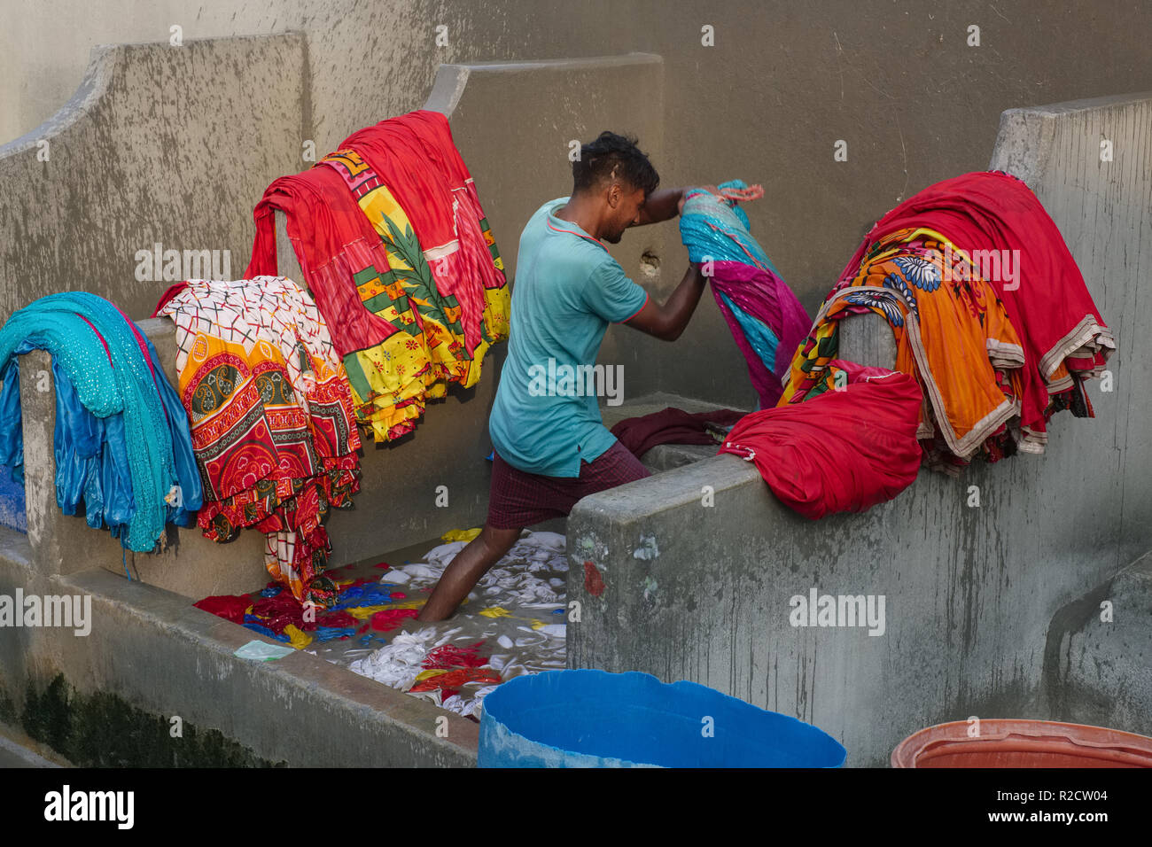 Ein Mann von der demütigen Dhobi oder Dhobi Kaste an walkeshwar Dhobi Ghat, einem kleinen Open-Air-Wäsche in Mumbai, Indien, das Waschen der Kleidung der farbige Frauen Stockfoto