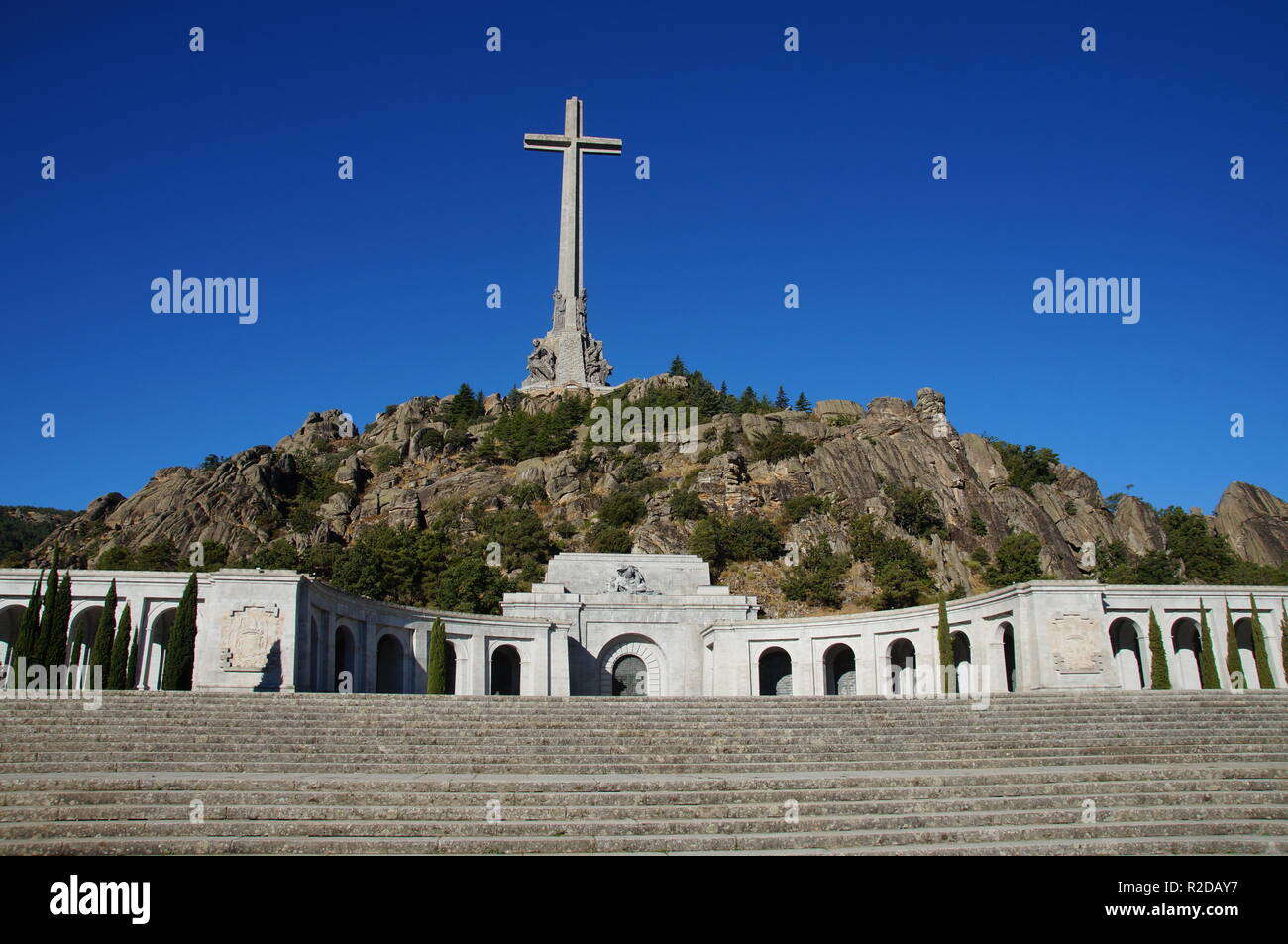 04 Oktober 2018, Spanien, El Escorial: Eine 155 Meter hohe und 44 Meter breite konkrete Kreuz steht auf dem Berg Risco de la Nava im Valle de los Caídos (Tal der Gefallenen) ca. 60 Kilometer nordwestlich von Madrid. Im Denkmal in der Sierra de Guadarrama ist das Grab des spanischen Diktators Franco. Drei Tage nach seinem Tod, wurde er in der Basilika am 23. November 1975 begraben. Das Mausoleum, das in den Felsen von 20.000 Zwangsarbeiter zwischen 1940 und 1959 vertrieben wurde, gilt als eine der größten der Welt. Es ist das wichtigste architektonische Symbol der Francos Diktatoren Stockfoto