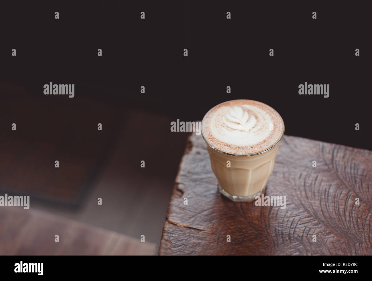 Heißen Cappuccino Tasse auf Holz- Fach mit latte Kunst auf Holz Tisch im Cafe. Essen und Trinken Konzept Stockfoto