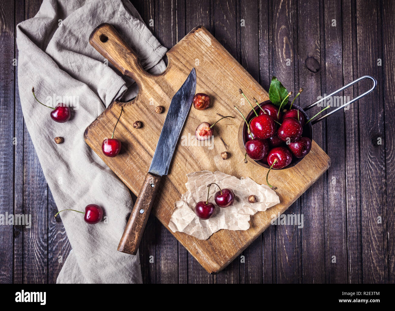 Kirsche auf dem Schneidebrett mit Messer auf hölzernen Tisch in der Küche Stockfoto