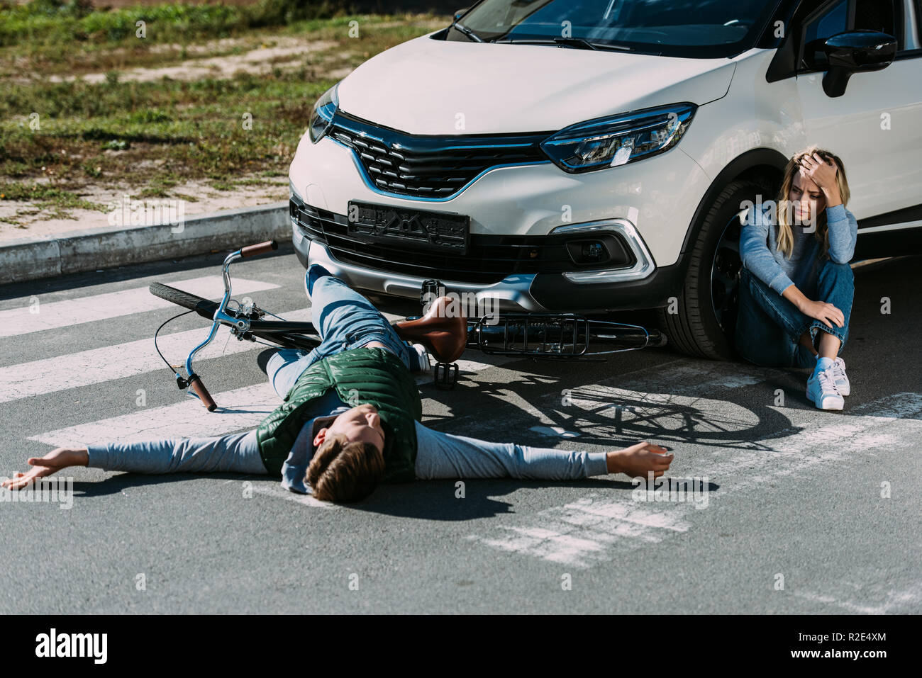 Hohe Betrachtungswinkel der Radfahrer liegen auf der Straße und der Angst Frau weinen in der Nähe von Autos nach Verkehr Zusammenstoß Stockfoto