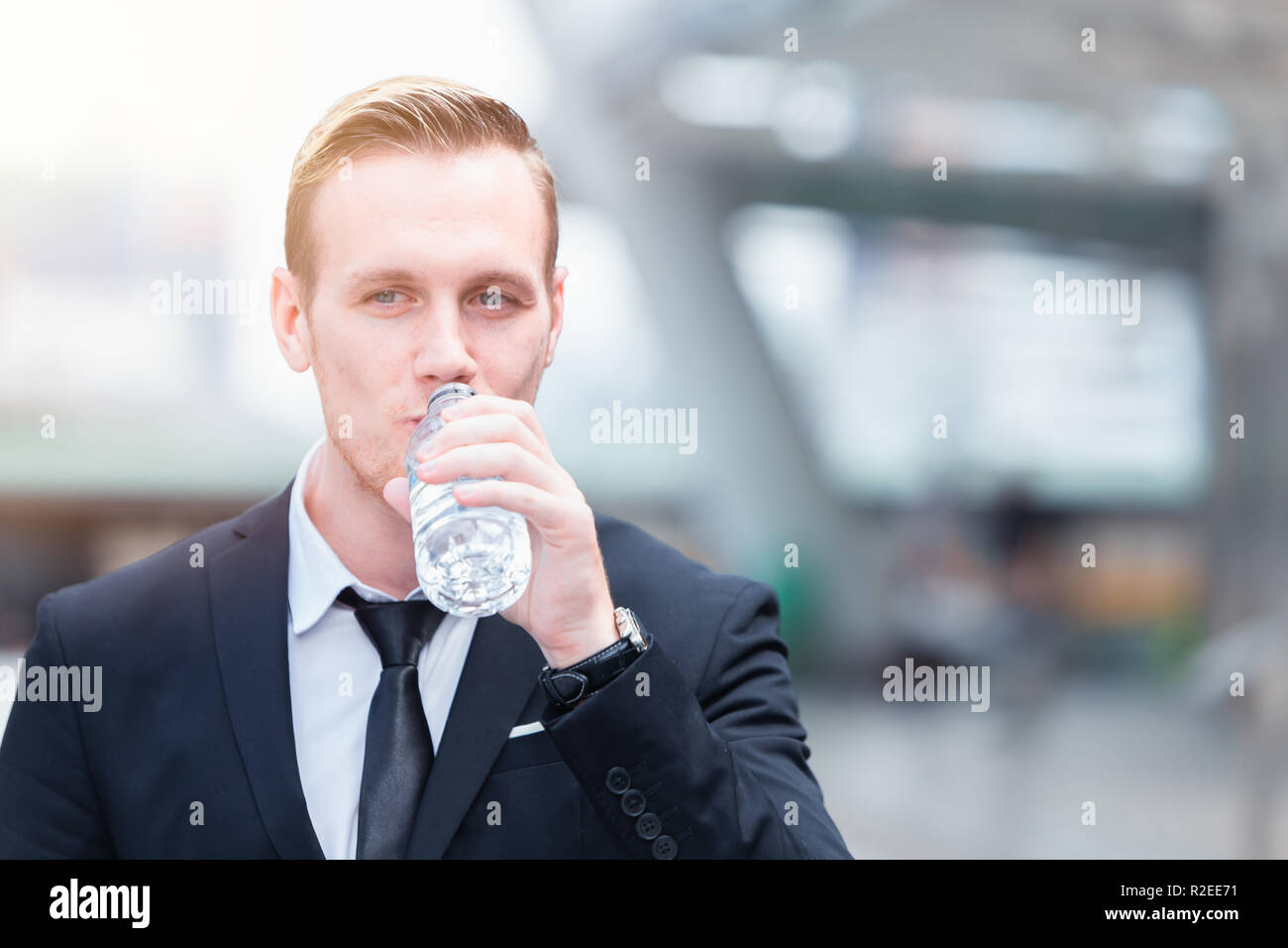 Geschäftsmann holding Flasche Wasser Trinkwasser aktualisieren für Unternehmen arbeiten. Stockfoto
