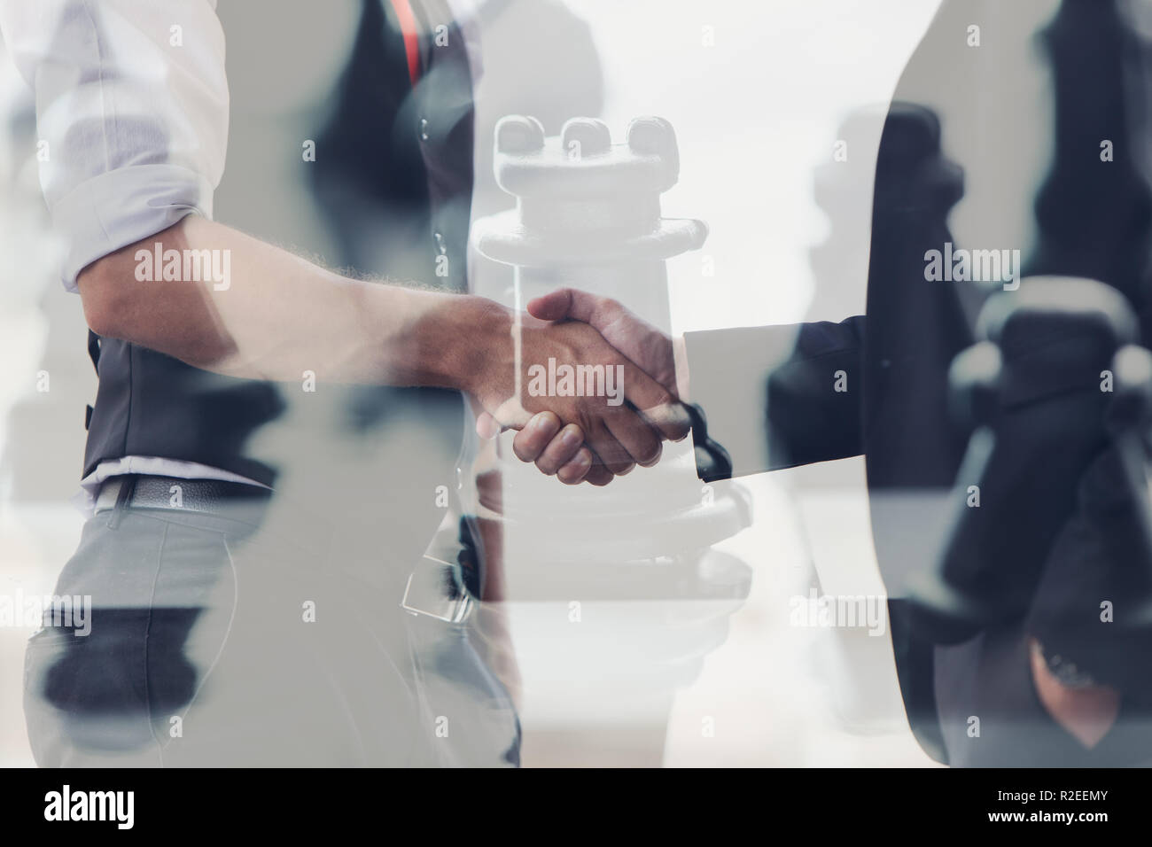Geschäftsmann die Hand schütteln Overlay mit Schach rook für Unternehmen führen Sie betrügen sich action concept. Stockfoto