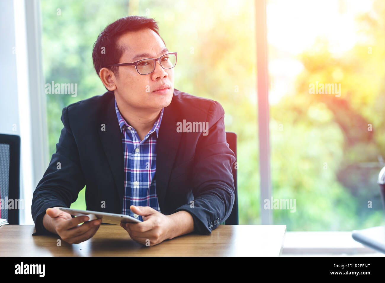 Asiatische Geschäftsmann weg schauen Denken mit Tablet für Vision und Technologie Konzept. Stockfoto