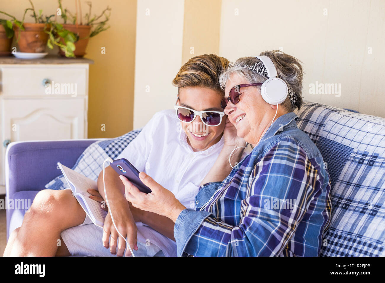 Paar junge und alte Großmutter und Teenager Neffe Familie Zeit zusammen Musik hören mit Kopfhörern und den Tag genießen. Glückliche Familie und Generationen verschiedene Altersgruppen Konzept Stockfoto
