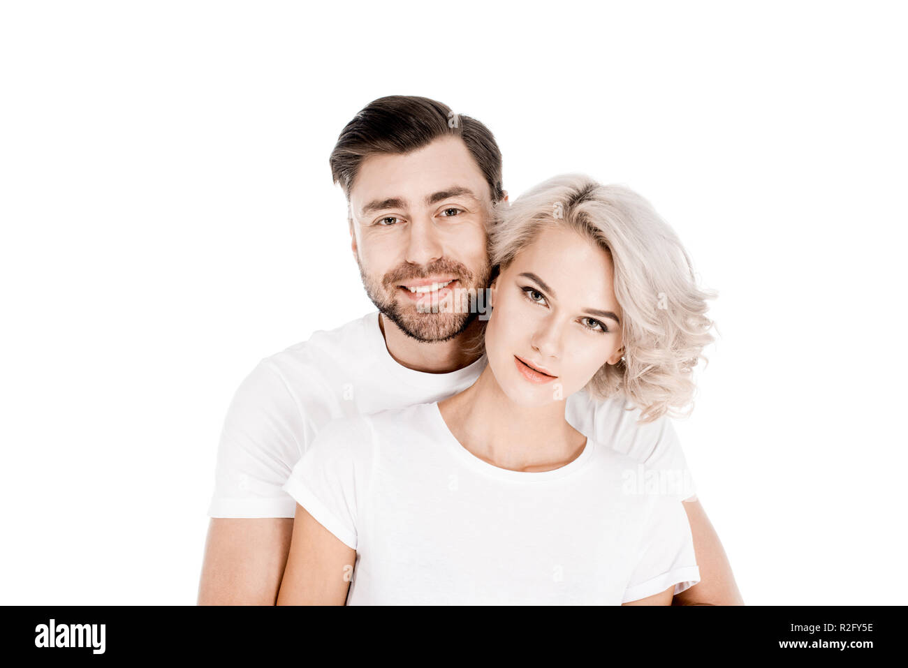 Attraktive junge Erwachsene Paar umarmen isoliert auf weißem Stockfoto
