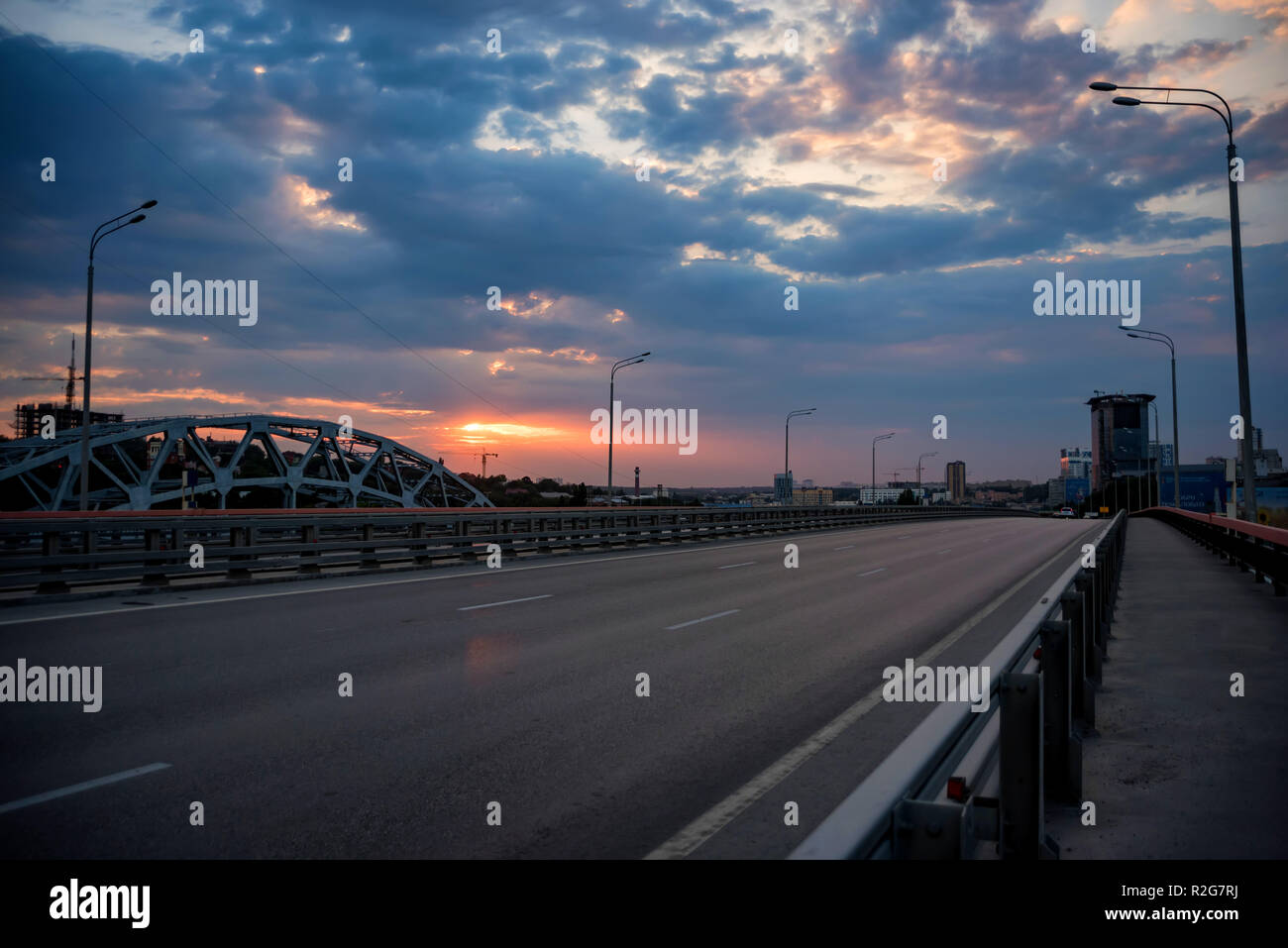 Blick auf moderne Beton Brücke über den Fluss bei Sonnenuntergang Stockfoto