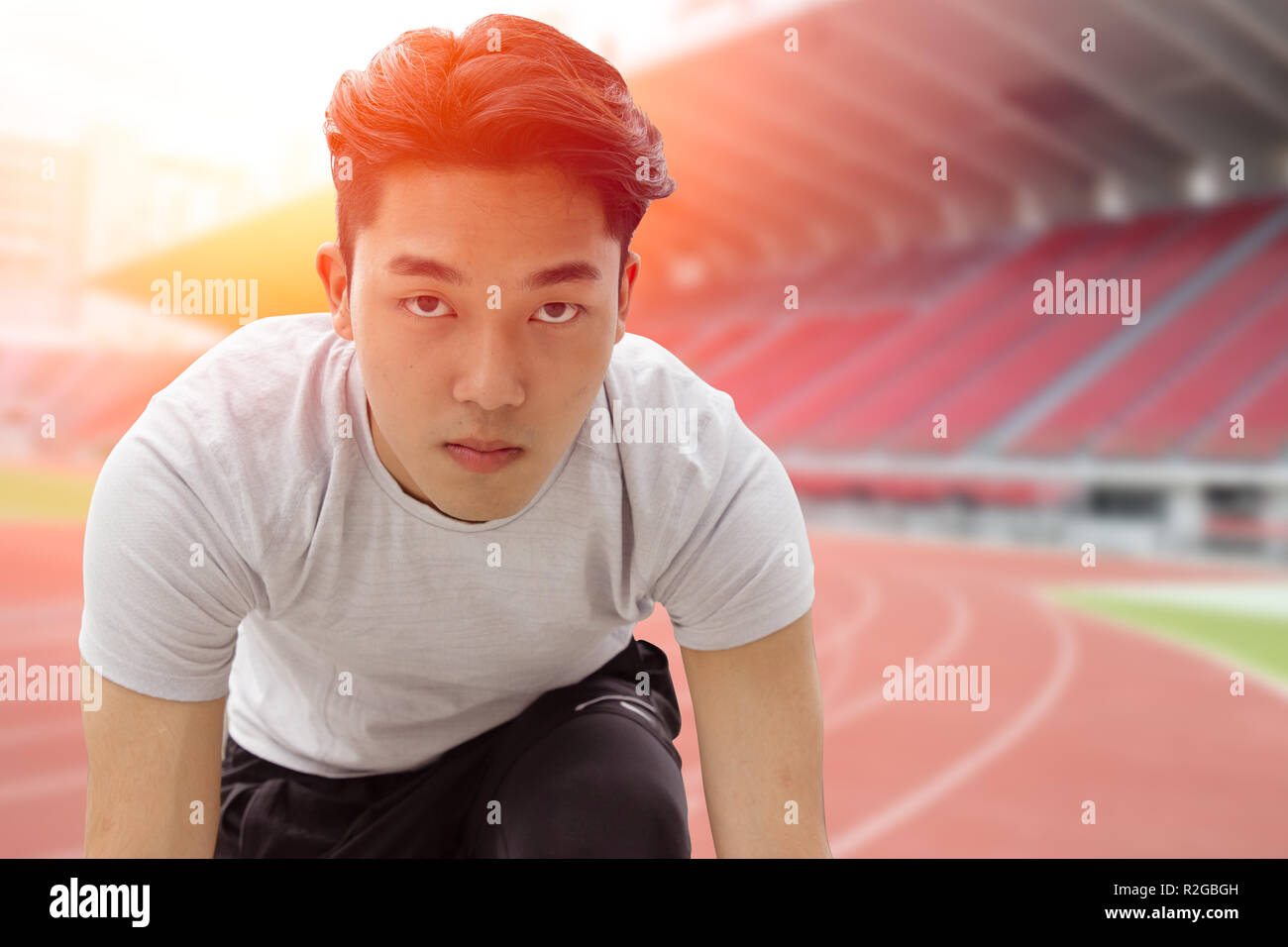 Asiatische Läufer Männer mit Schwerpunkt Augen begangen mit Sport Stadion Hintergrund zu starten. Stockfoto