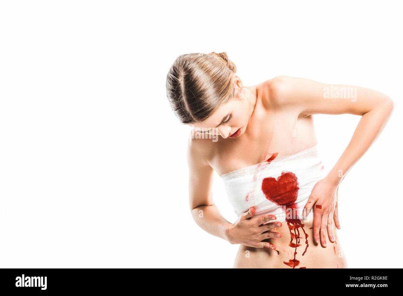 Erwachsene Frau in Bandagen an blutige Herz an Isolated On White Stockfoto