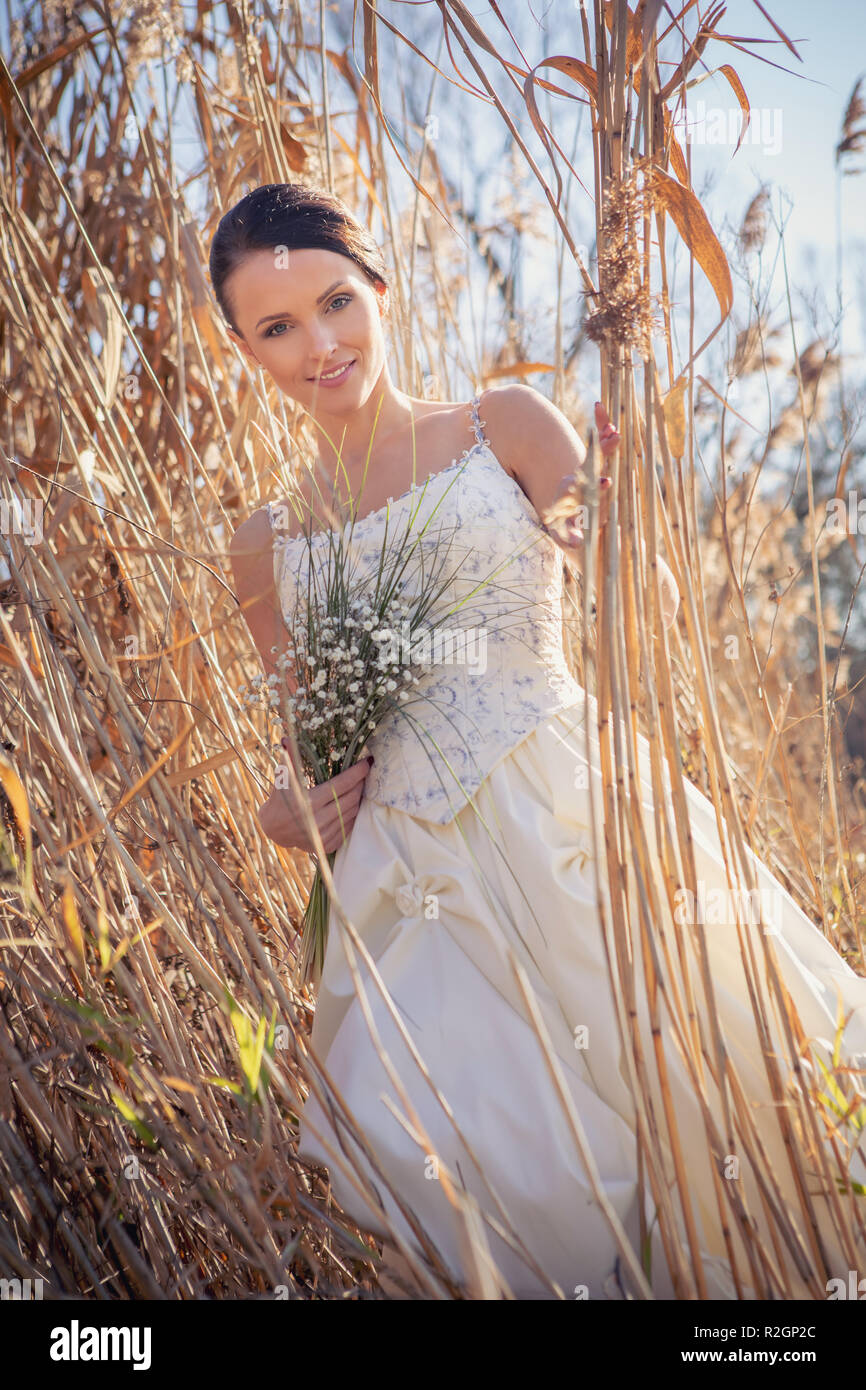 Outdoor Portrait einer Braut mit Brautstrauß in einem Hochzeitskleid Stockfoto