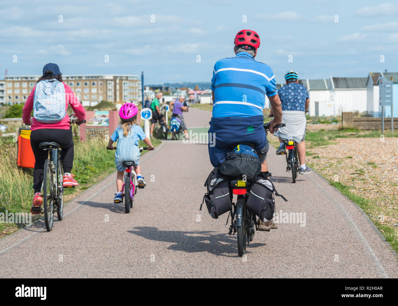 Eine Familie mit dem Fahrrad entlang der Promenade Weg für Fußgänger und Radfahrer im Sommer in Großbritannien. Stockfoto