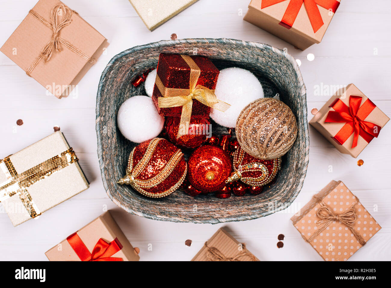 Silver Box mit präsentiert und rote Bälle durch präsentiert auf weißen Hintergrund Holz umgeben. Flach. Weihnachten Konzept. Stockfoto