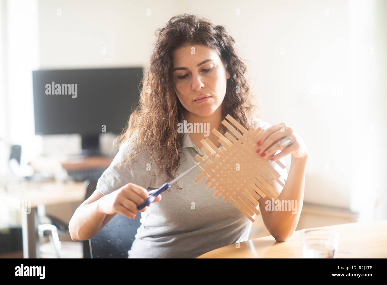 Frau sitzt an einem Tisch upcycling einen Milchkarton Stockfoto