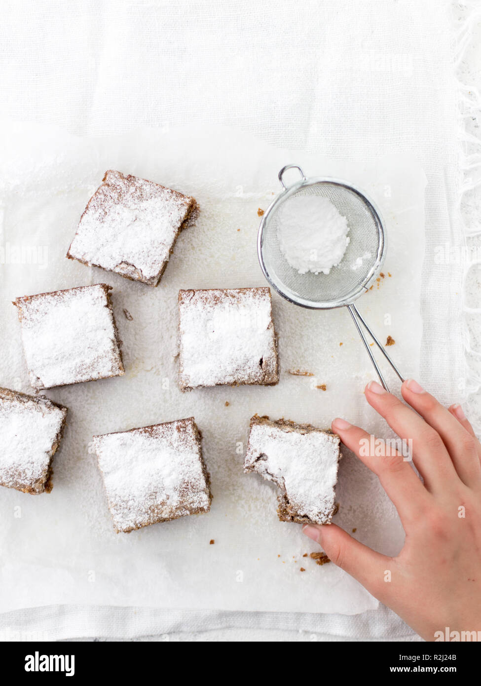 Woman's Hand erreichen für eine weiße Schokolade Karamell blondies Stockfoto