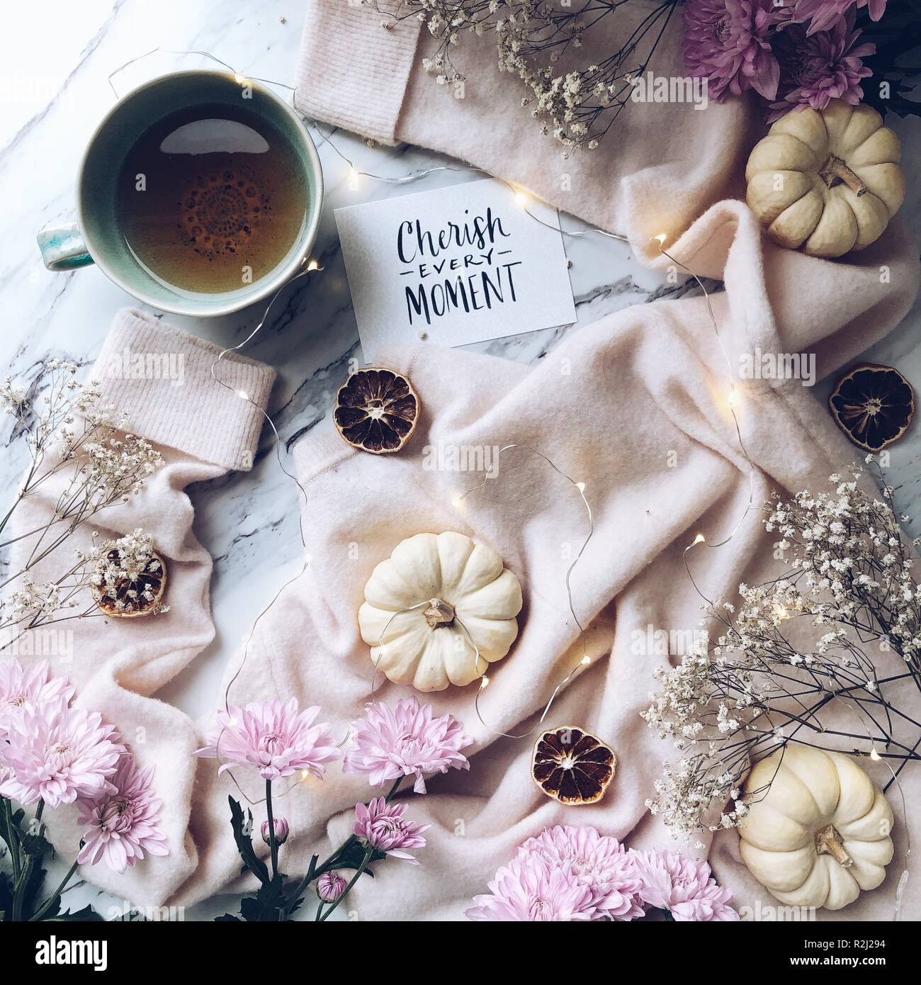 Tasse Tee, Kürbis und Blumenarrangements Stockfoto