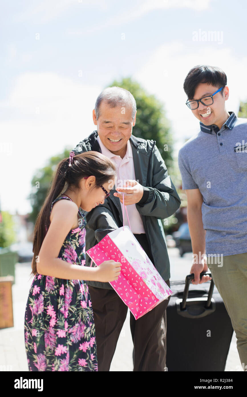 Großvater Familie besucht, überraschende Enkelin mit Geschenk Stockfoto