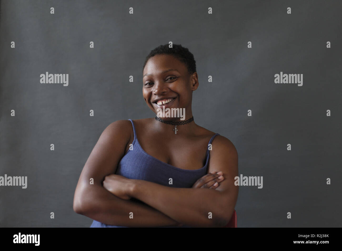 Porträt Lächeln, selbstbewusste Frau mit verschränkten Armen Stockfoto