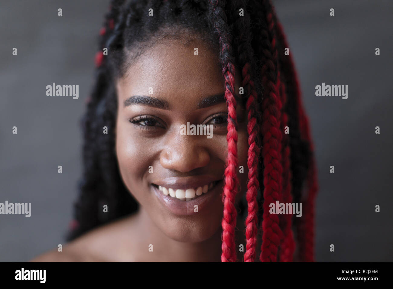 Porträt Lächeln, selbstbewussten jungen Frau mit roten Zopf Stockfoto