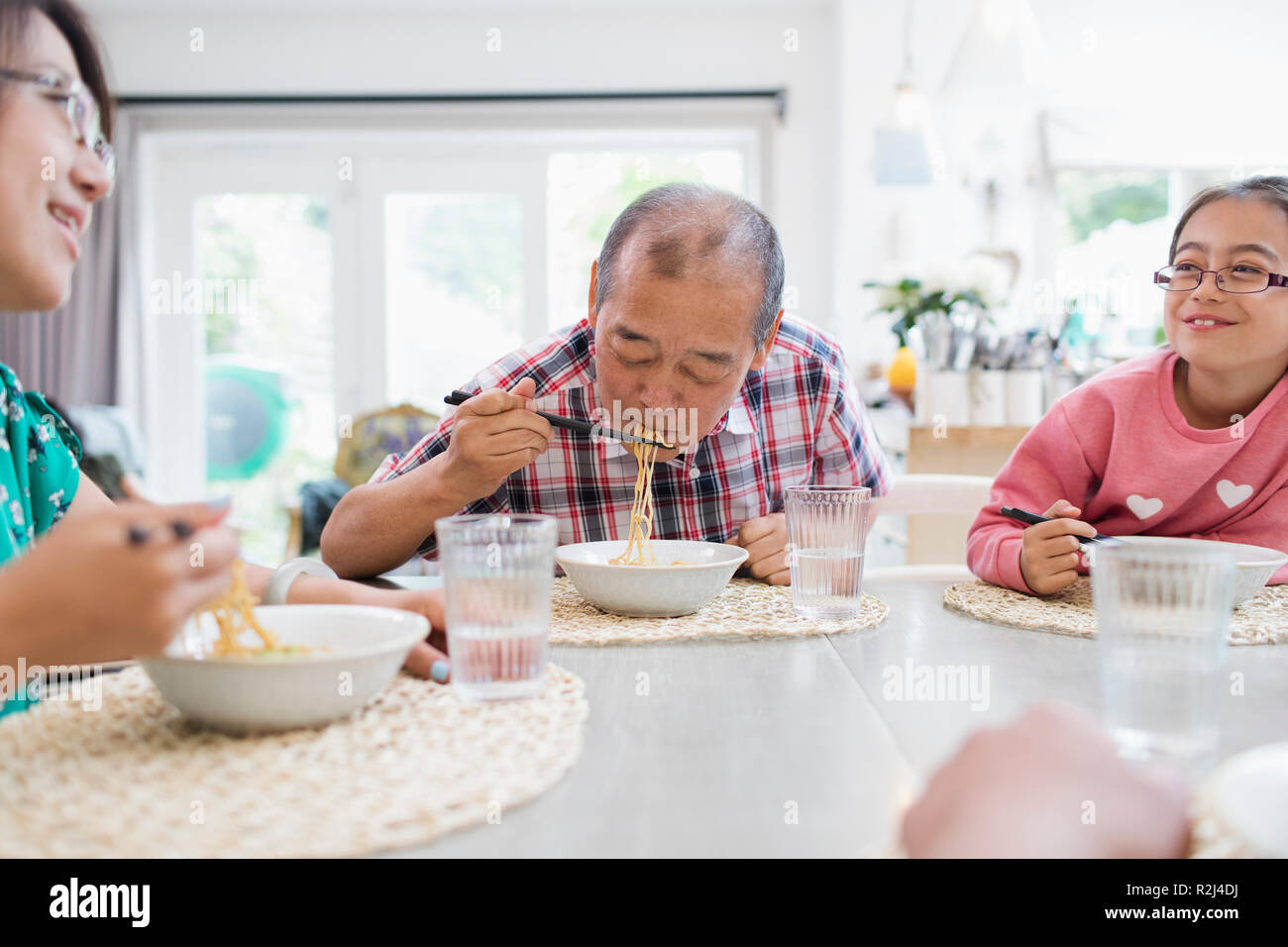 Multi-Generation, Familie Nudeln essen mit Stäbchen an den Tisch Stockfoto