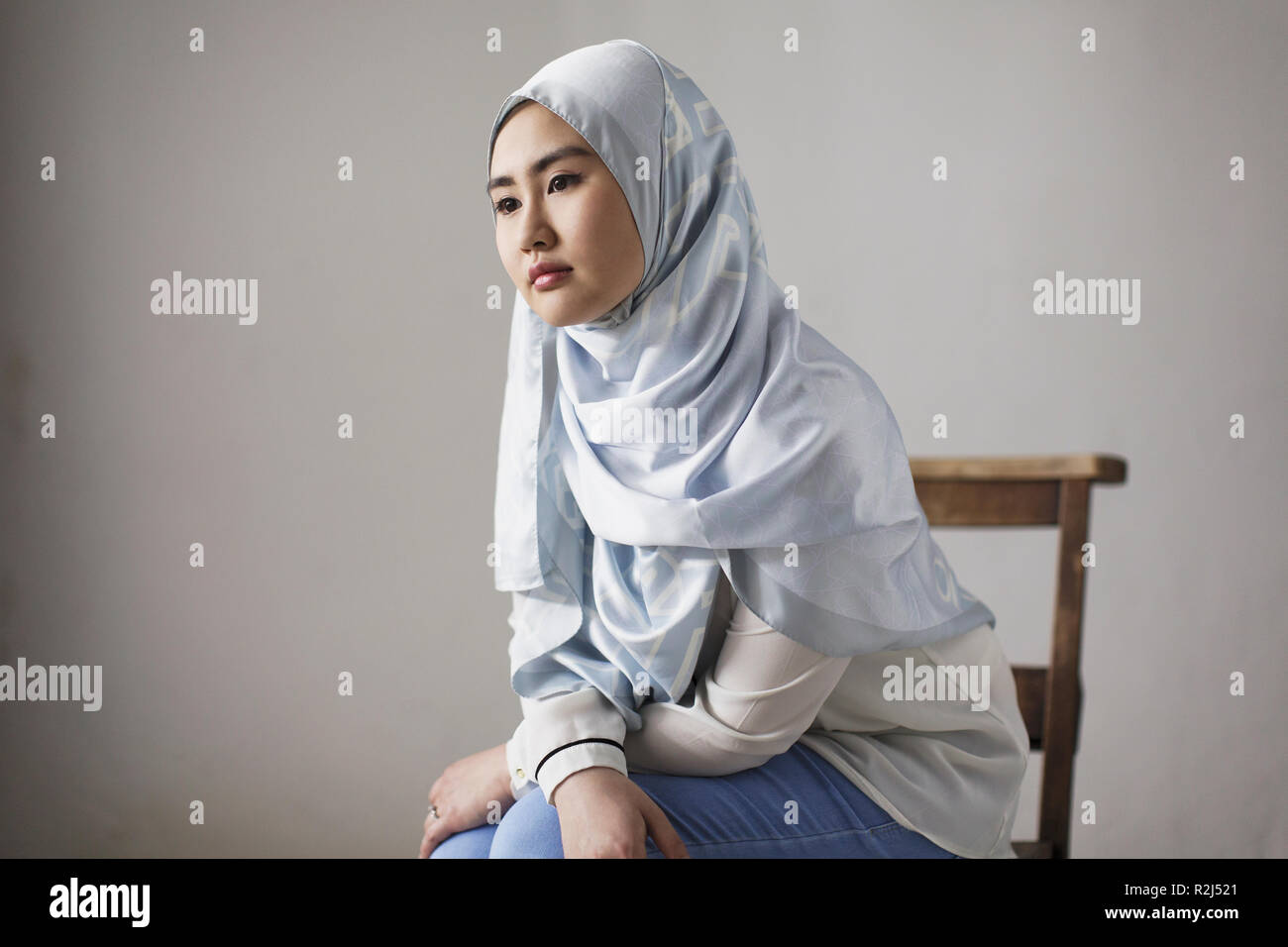 Nachdenkliche junge Frau in blauer Seide hijab Stockfoto