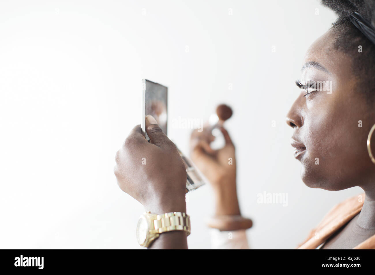 Frau Anwendung Make-up in kompakten Spiegel Stockfoto