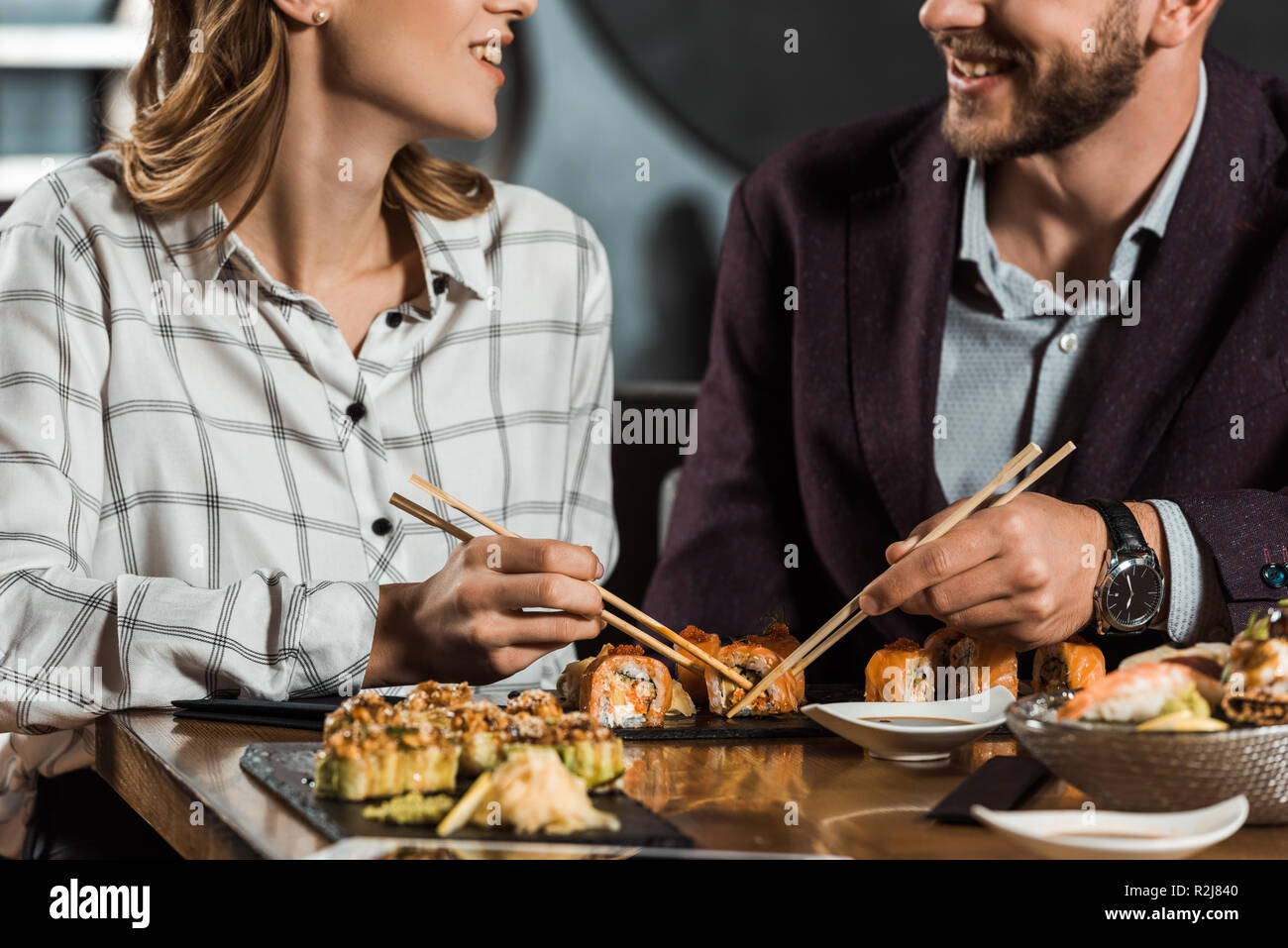Teilweise mit Blick auf die lächelnde Paar Sushi essen im Restaurant Stockfoto