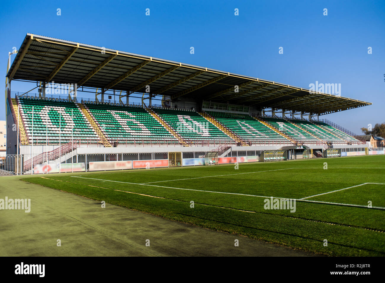 Fußballtor net mit wenig Tribüne auf Hintergrund und bunten Gras und Sky Stockfoto