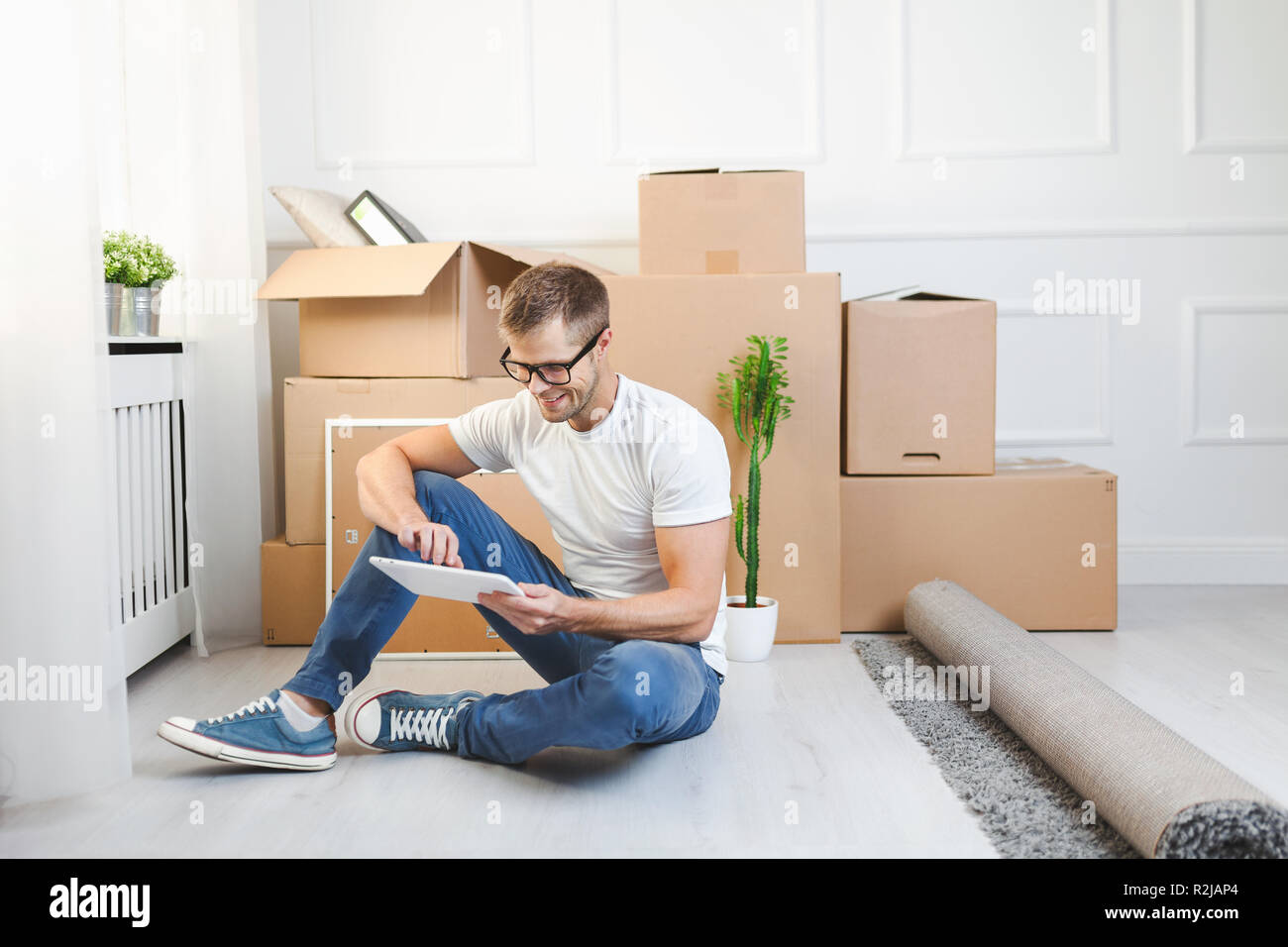 Hübscher junger Mann in seinem neuen Zuhause bewegen Stockfoto