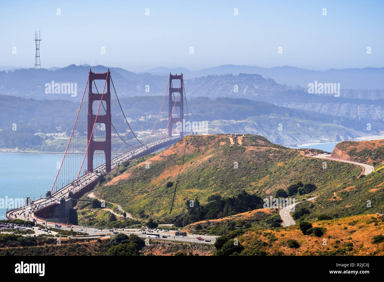Luftaufnahme der Golden Gate Bridge und der Autobahn durch die grünen Hügel von Marin Headlands an einem sonnigen Morgen begrenzt; San Francisco Bay Area. Stockfoto