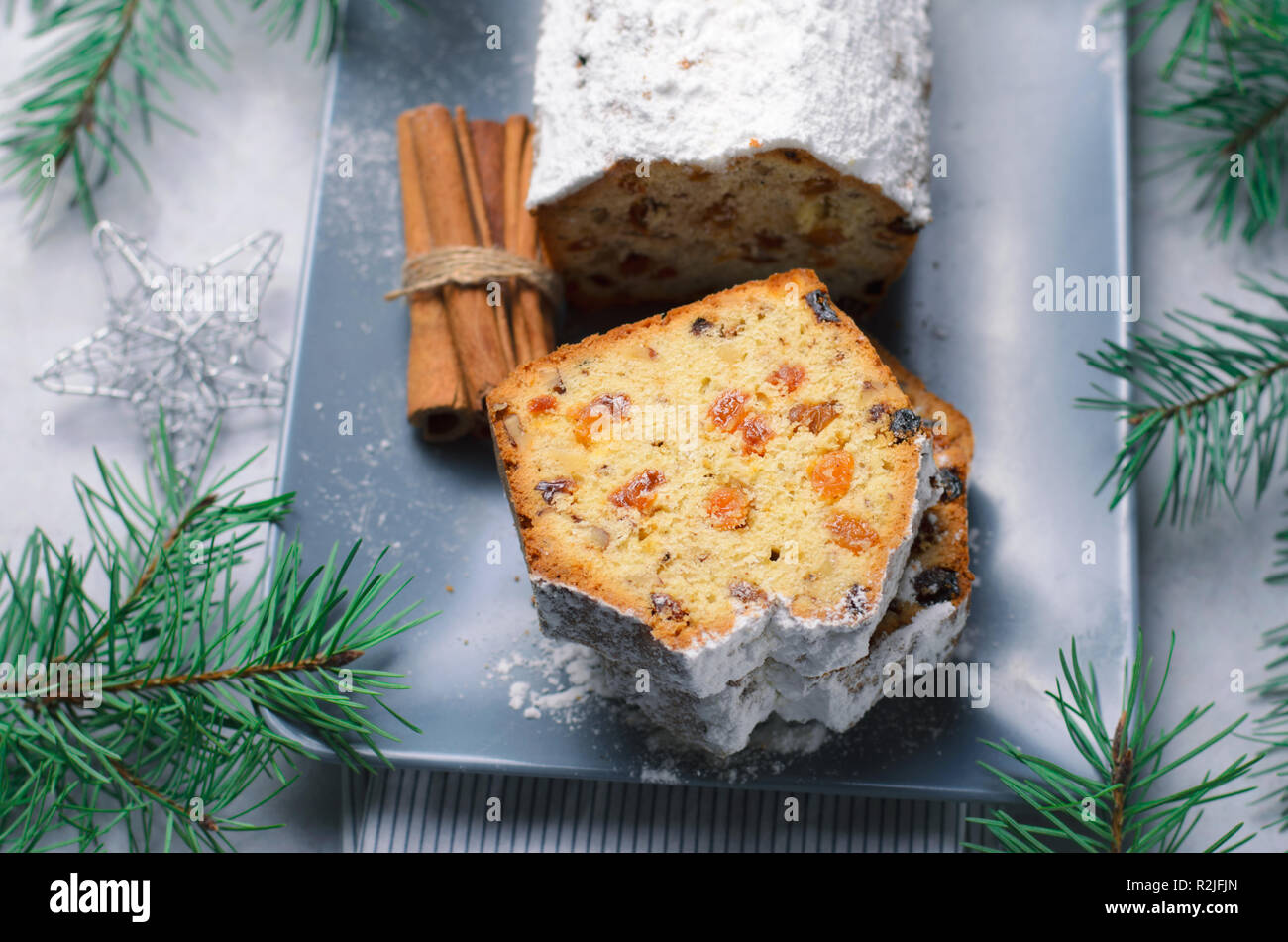Obst und Mutter Brot Kuchen mit Puderzucker bestäubt, Weihnachten und Winter Urlaub gönnen, hausgemachte Kuchen mit Rosinen auf grauem Hintergrund Stockfoto
