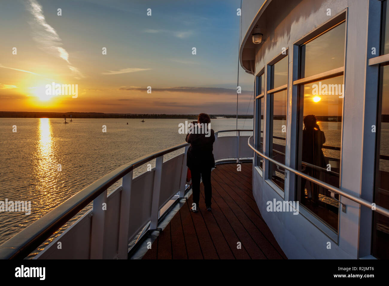 Sonnenuntergang auf See Onega, Russland. Weibliche Tourist, der ein Bild vom Schiff auf dem See. Stockfoto
