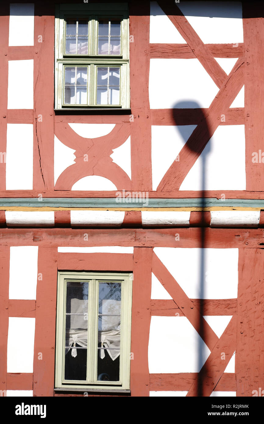 Eine Straßenlaterne wirft einen Schatten auf die hellen Fassade und den Strahl Bau eines Fachwerkhauses, Stockfoto