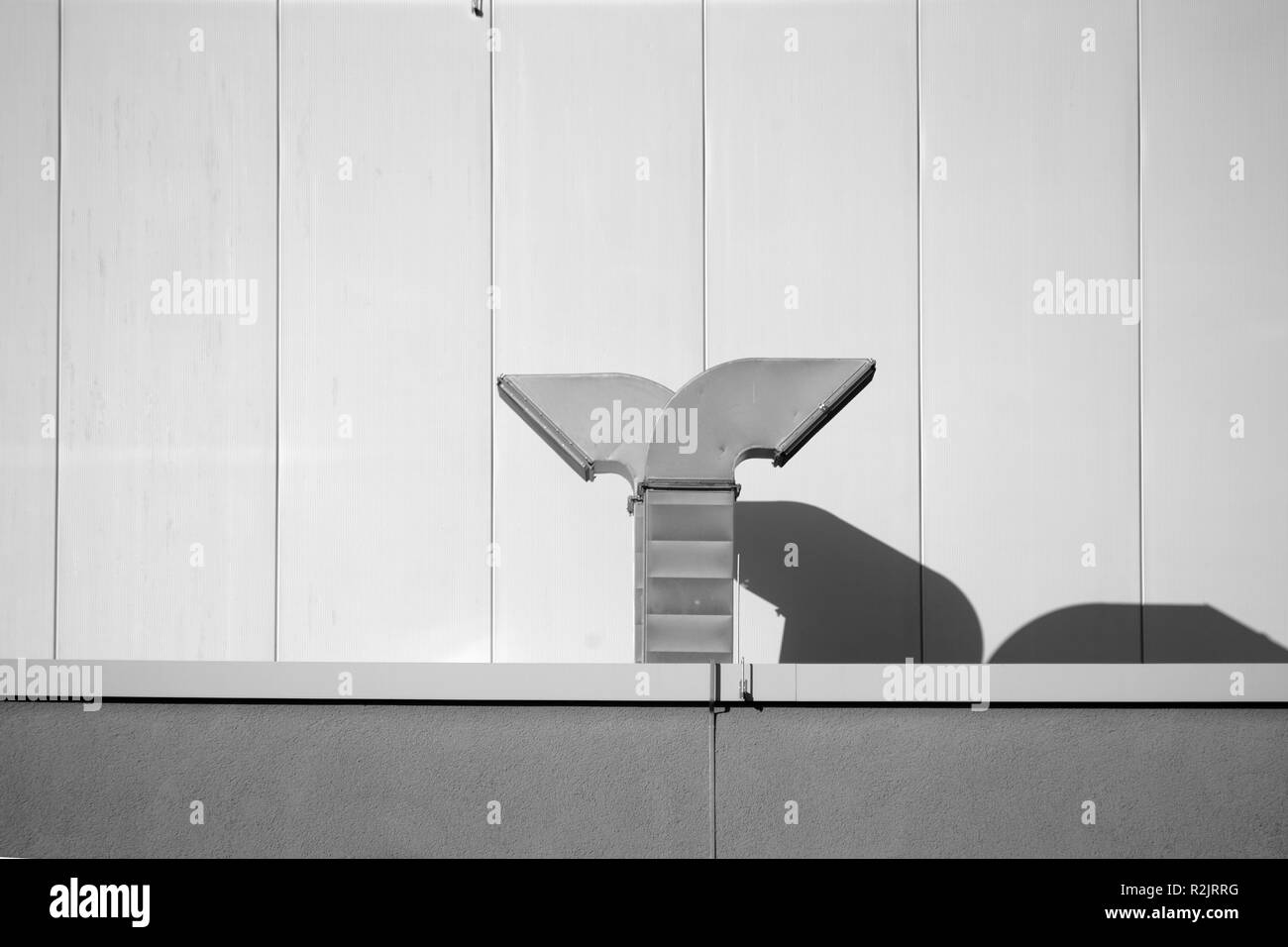 Dunstabzugshauben in der traufe eines modernen Gebäudes werfen Schatten, Stockfoto