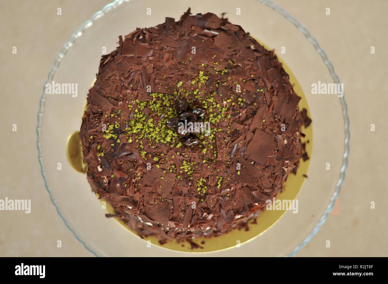 Köstliche frische Schokolade Pistaccio Kuchen mit Schokolade Stück um und Pistazien auf oben auf Glasplatten serviert mit Weihnachten Dekoration Stockfoto