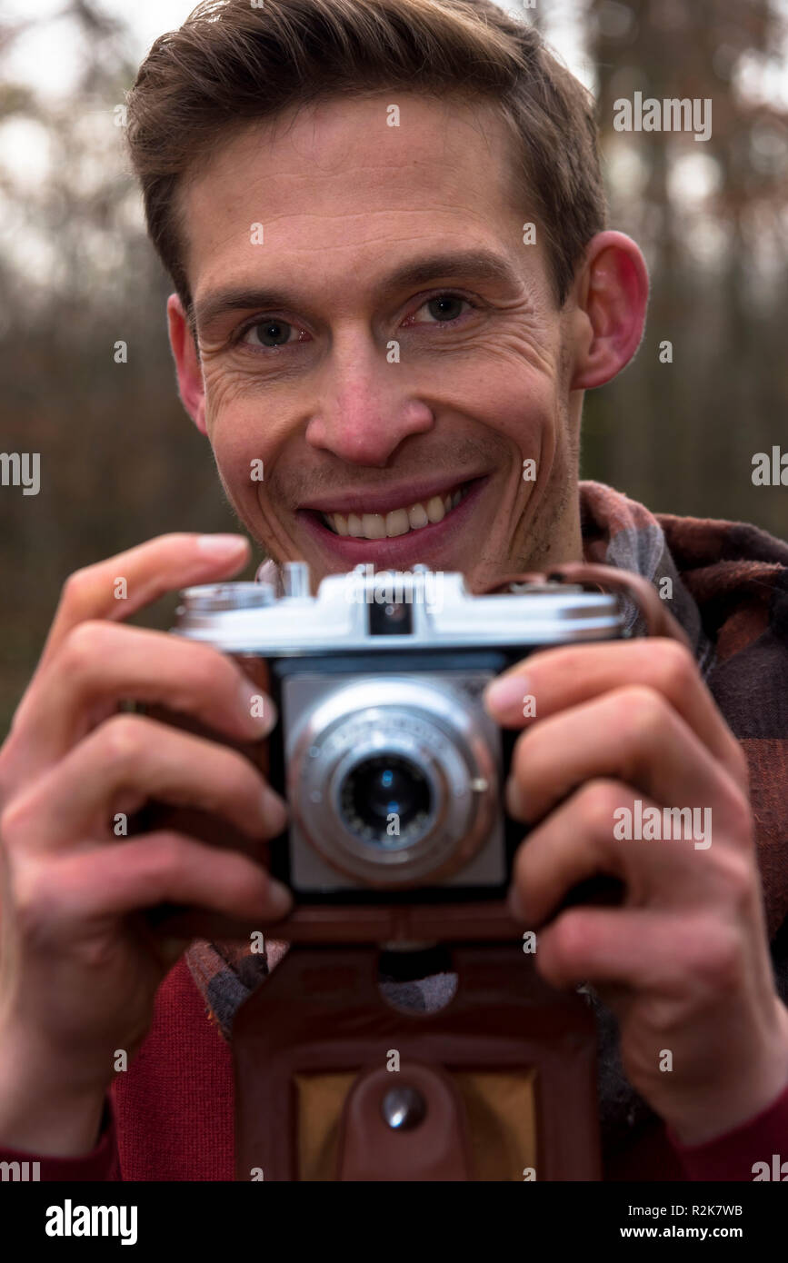 Junger Mann, Lächeln, Kamera, Holding, Porträt, Stockfoto