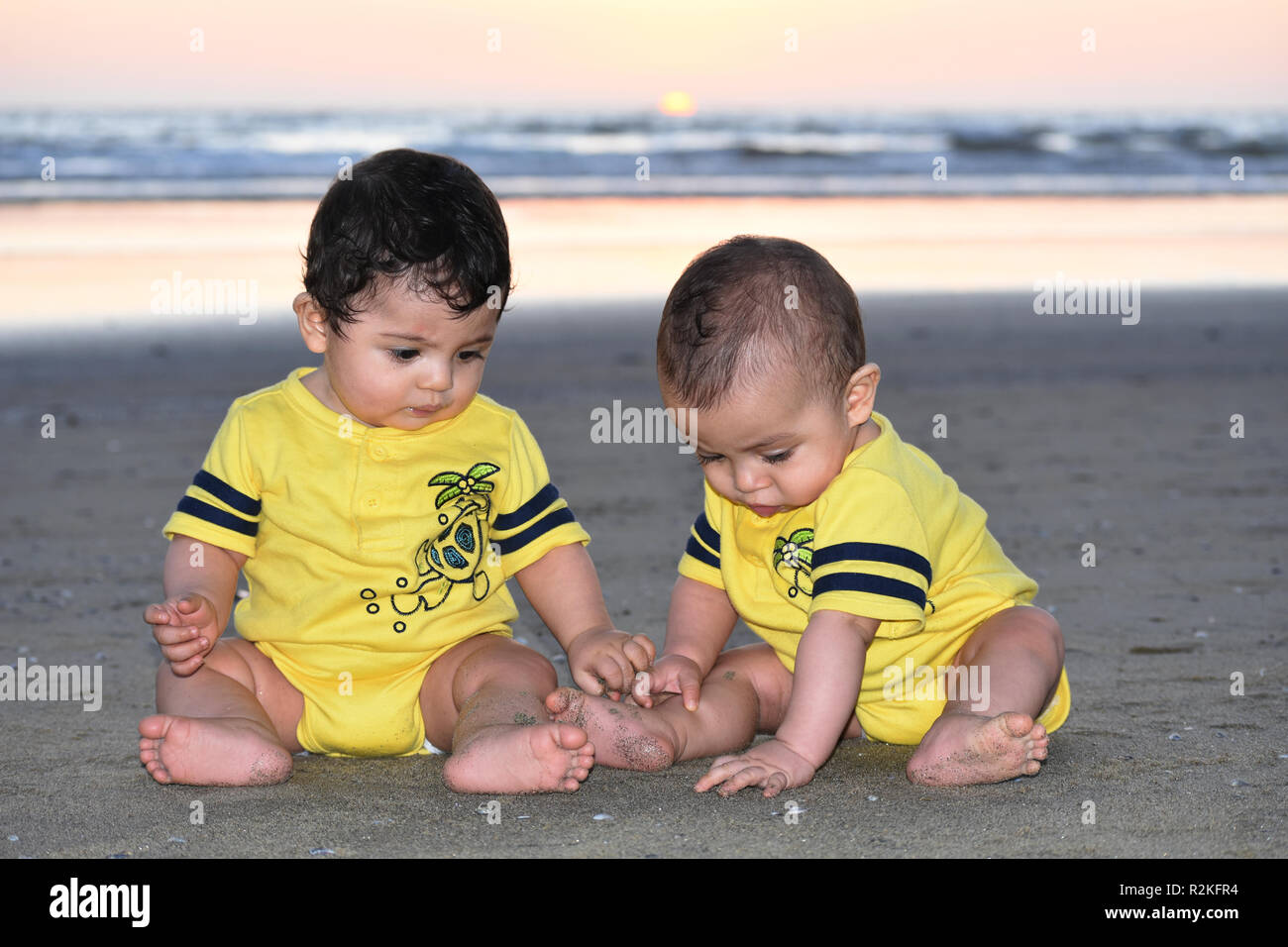 Twin baby Brüder spielen mit dem Sand am Strand Stockfoto