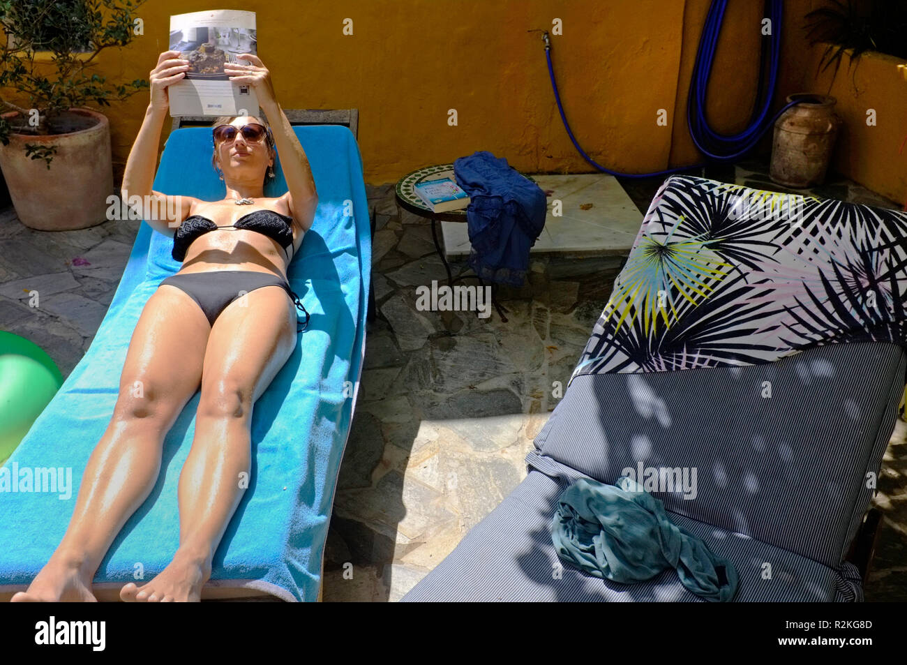 Eine Frau mittleren Alters Lesen auf einem Subbed auf Ihren Urlaub. Stockfoto