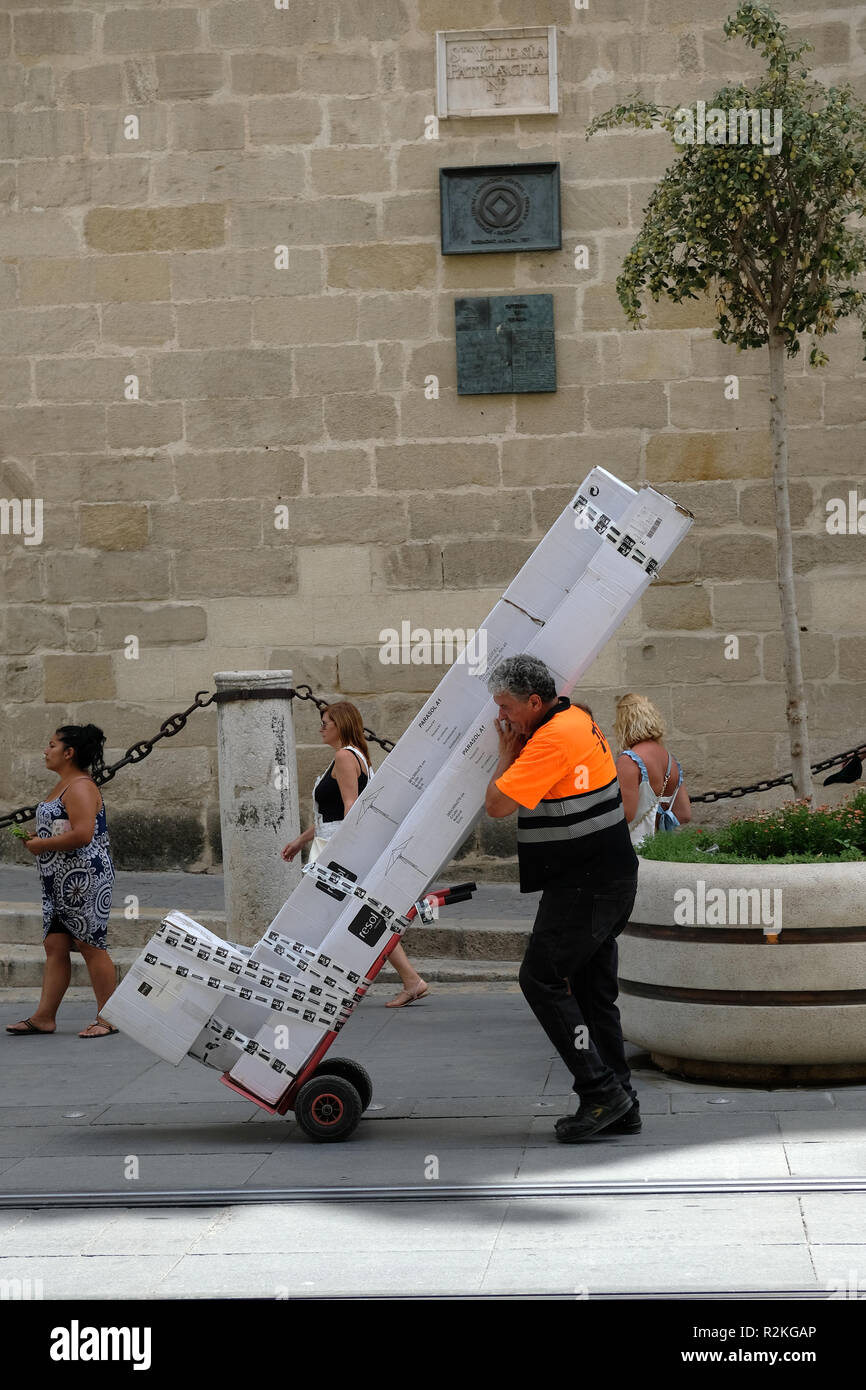 Ein Mann mit einem großen Paket in Sevilla, Spanien. Stockfoto