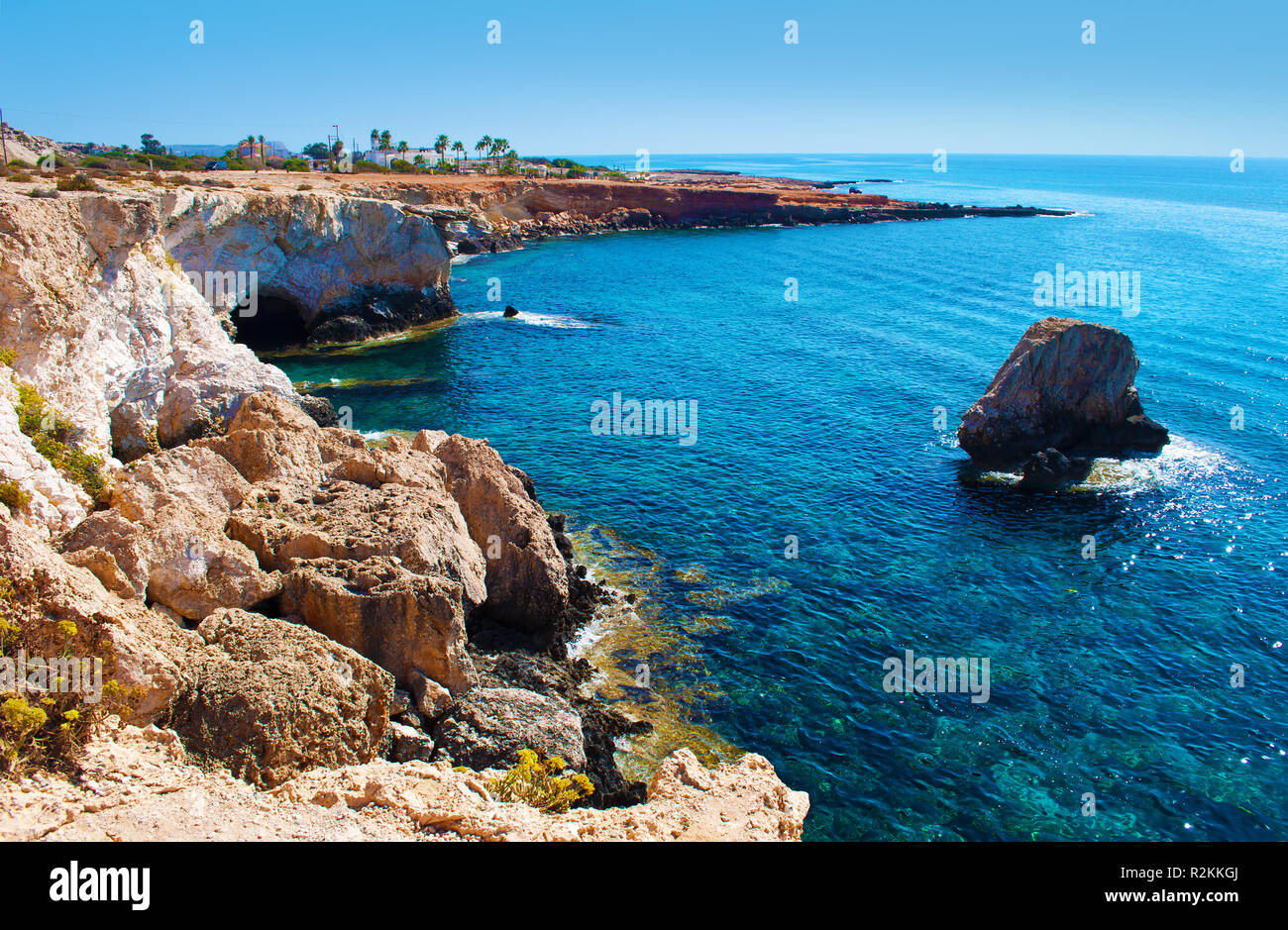 Blick auf die Höhle und Kap in der Nähe von Agia Napa, Zypern, majestätischen natürlichen Sehenswürdigkeiten. Gelb Braun hohe Felsen in der Nähe von transparenten unglaublich blauen Wasser und Durchfluss Stockfoto