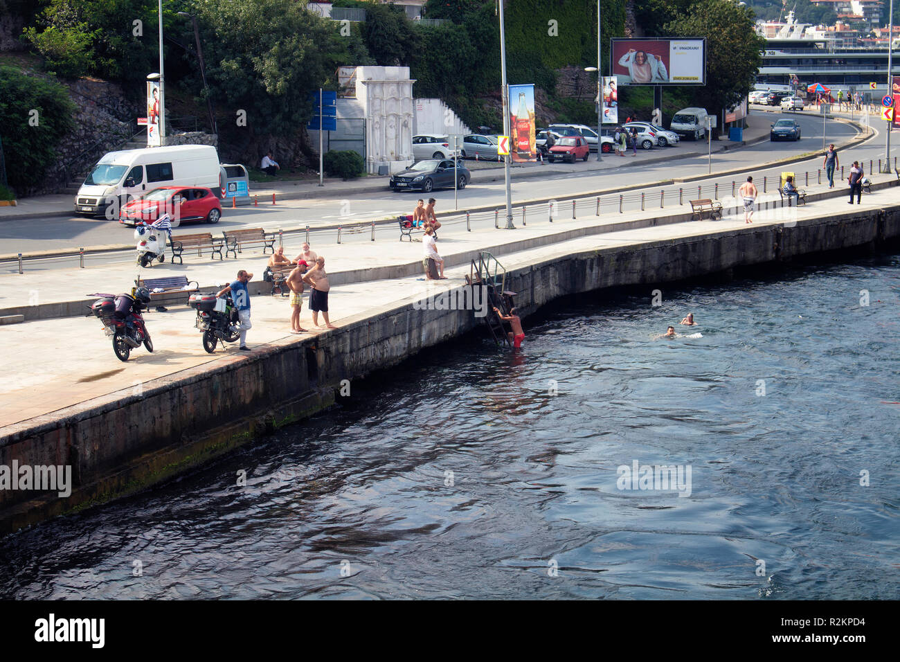 Anzeigen von Menschen schwimmen durch den Bosporus. Autos, die auf dem Verkehr sind im Hintergrund. Es ist ein sonniger Sommertag in Istanbul. Stockfoto