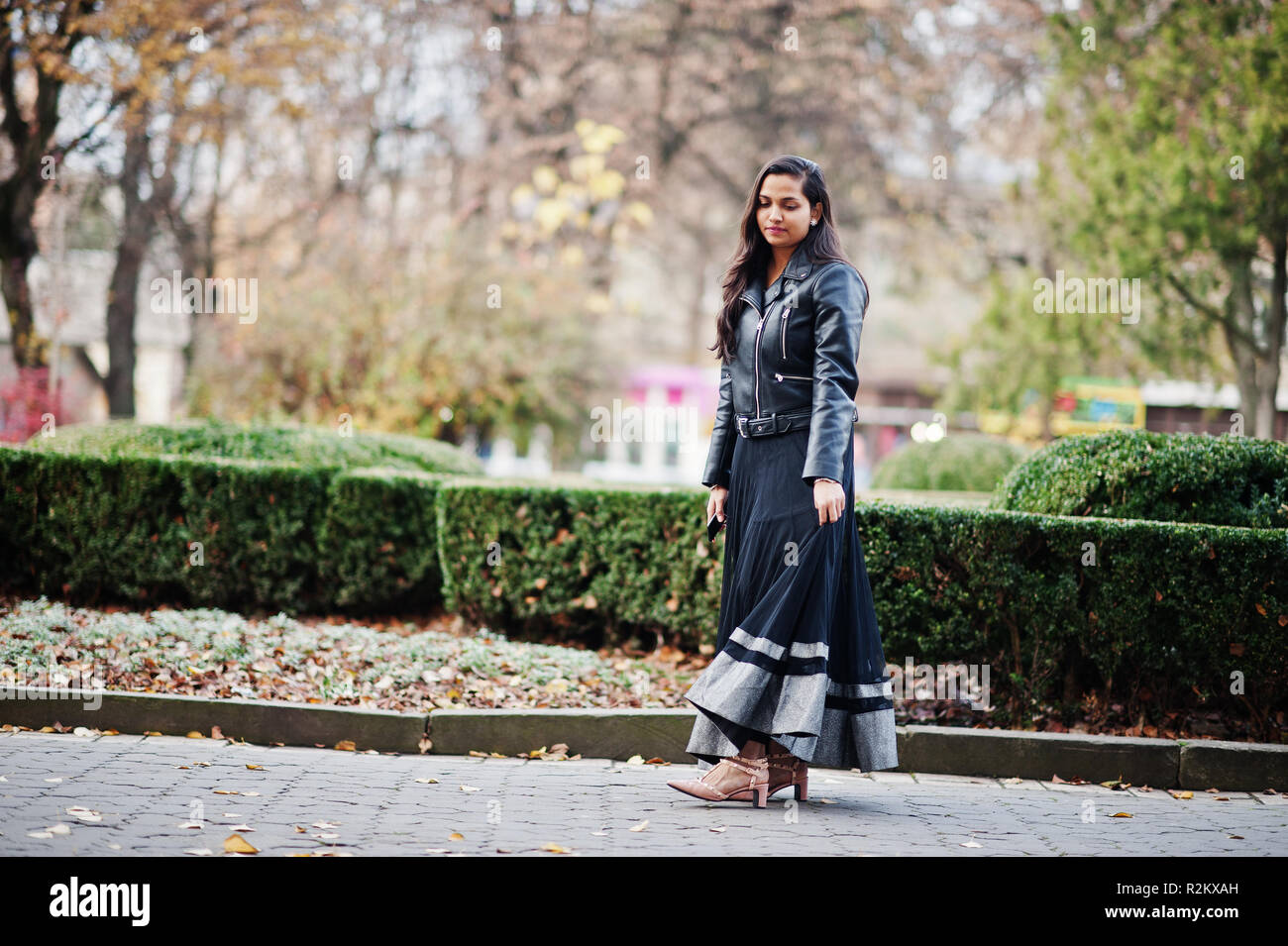 Schöne indische Mädchen in schwarz Sari Kleid und Lederjacke stellte im Freien im Herbst Straße. Stockfoto