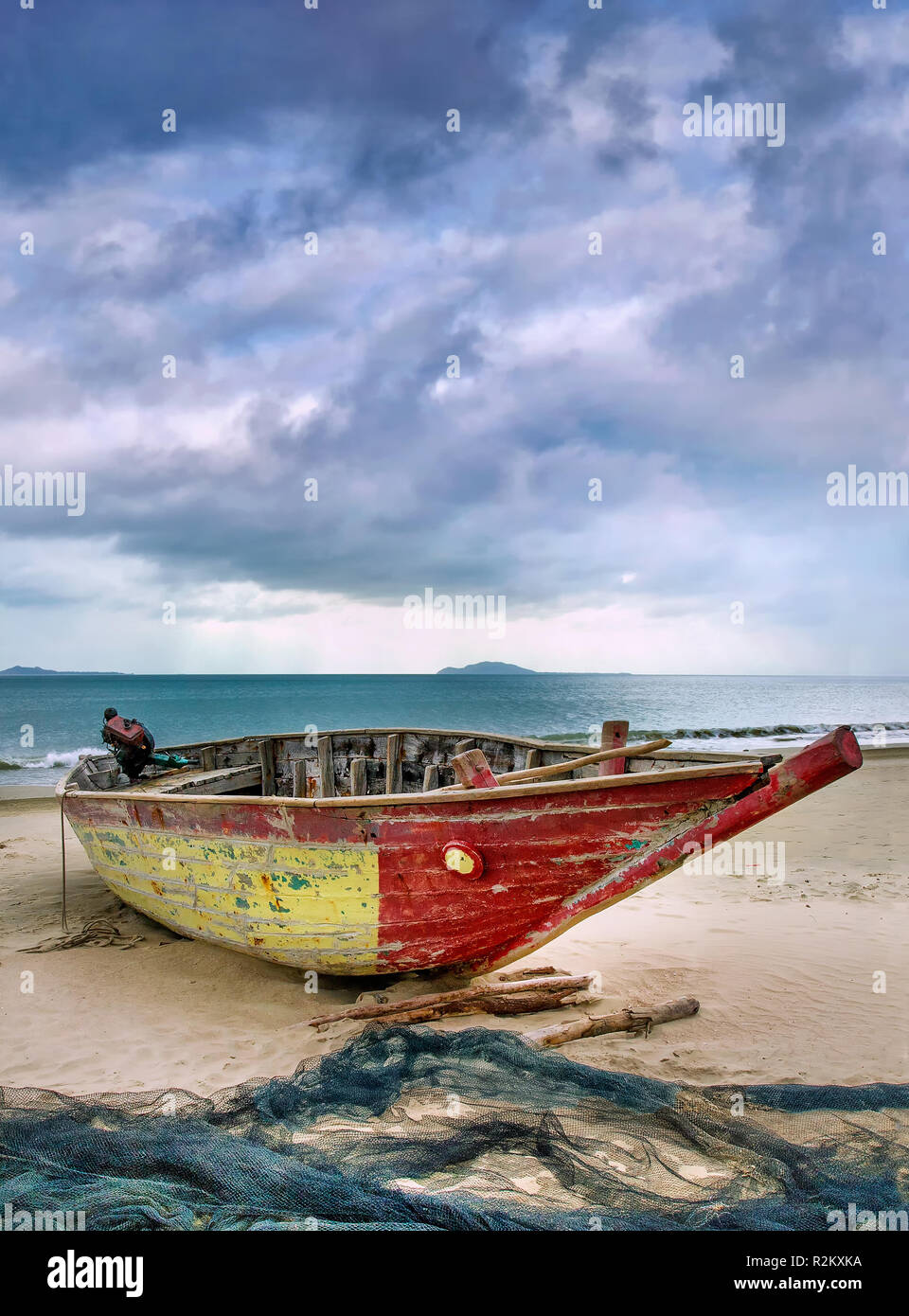 Old wooden Fisher-Boot an einem bewölkten Strand, Sanya, China. Stockfoto