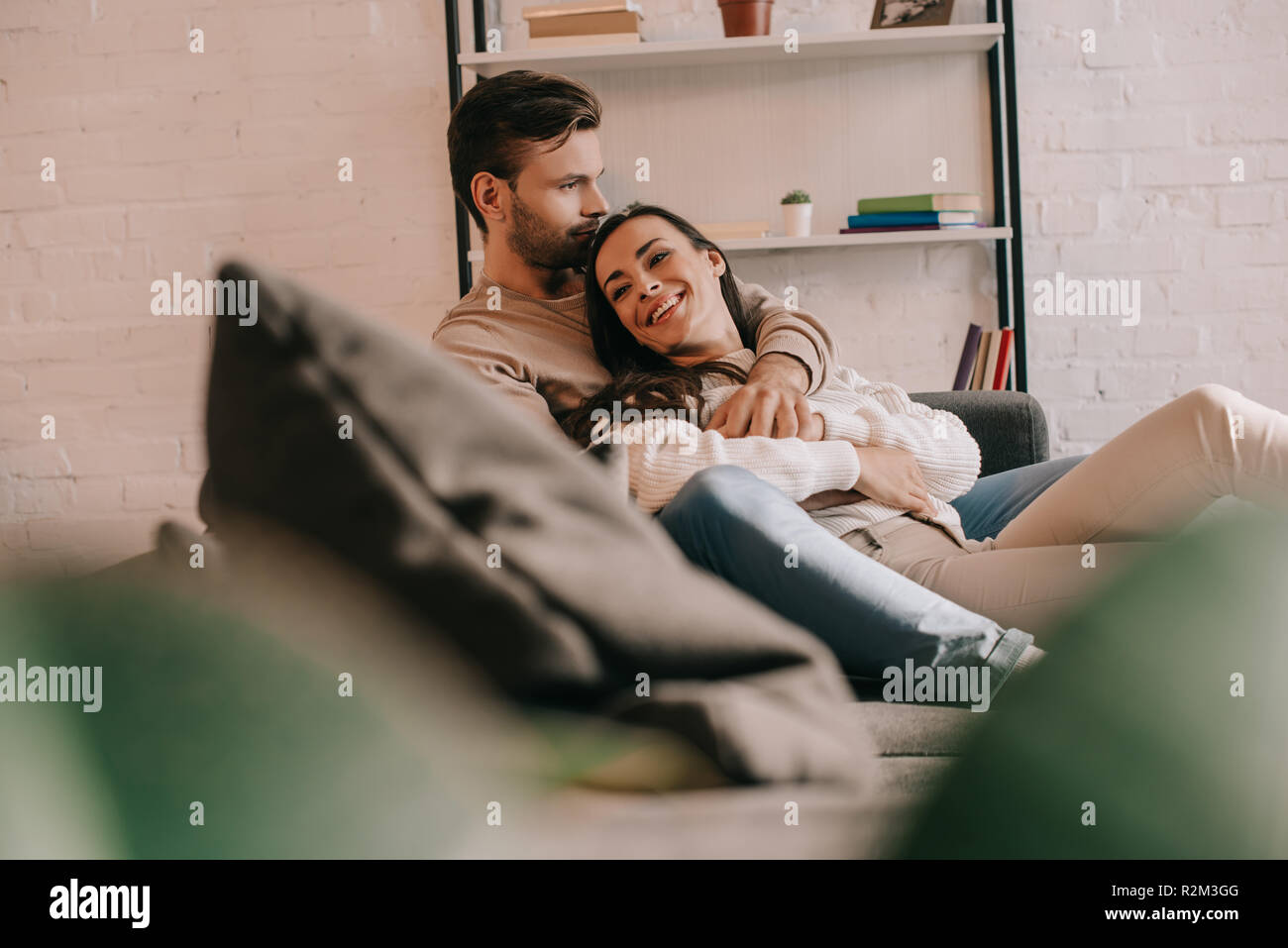 Attraktive junge Paar kuscheln auf der Couch zu Hause Stockfoto