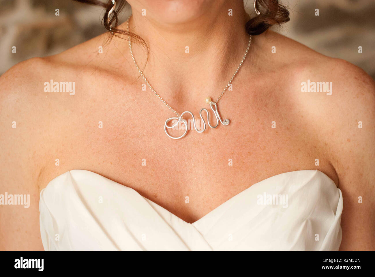 Braut an ihrem Hochzeitstag trägt eine Kette mit Oui Stockfoto