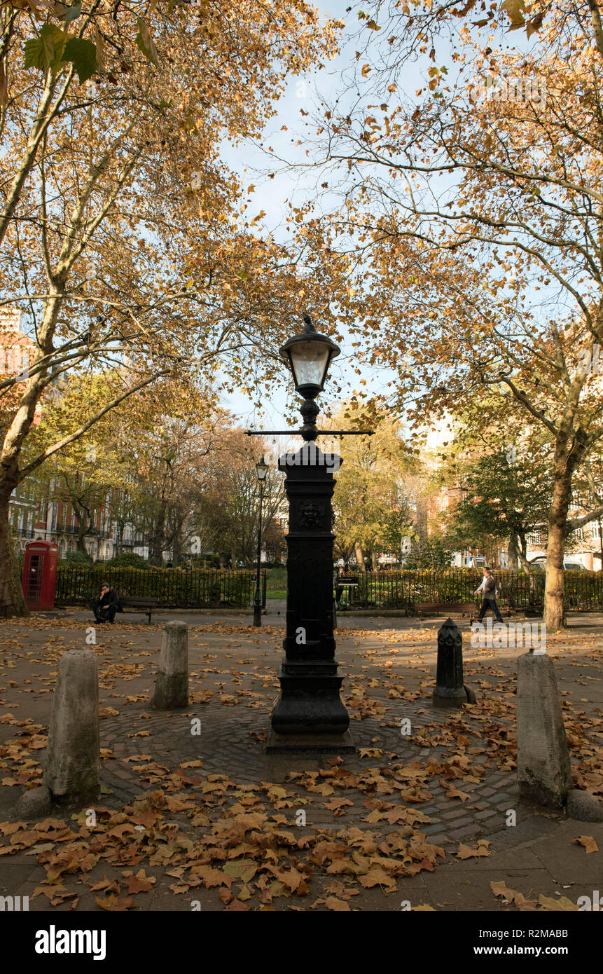 Wasserpumpe mit vier Poller mit Lampe oben Queen Square Bloomsbury London England Großbritannien UK umgeben Stockfoto