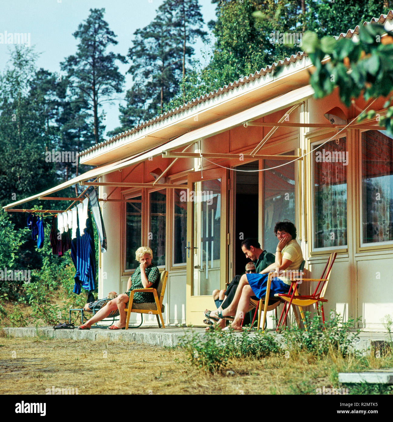 Urlauber vor den Bungalows im FDGB Holiday Village Klink an der Müritz in Mecklenburg-Vorpommern Stockfoto